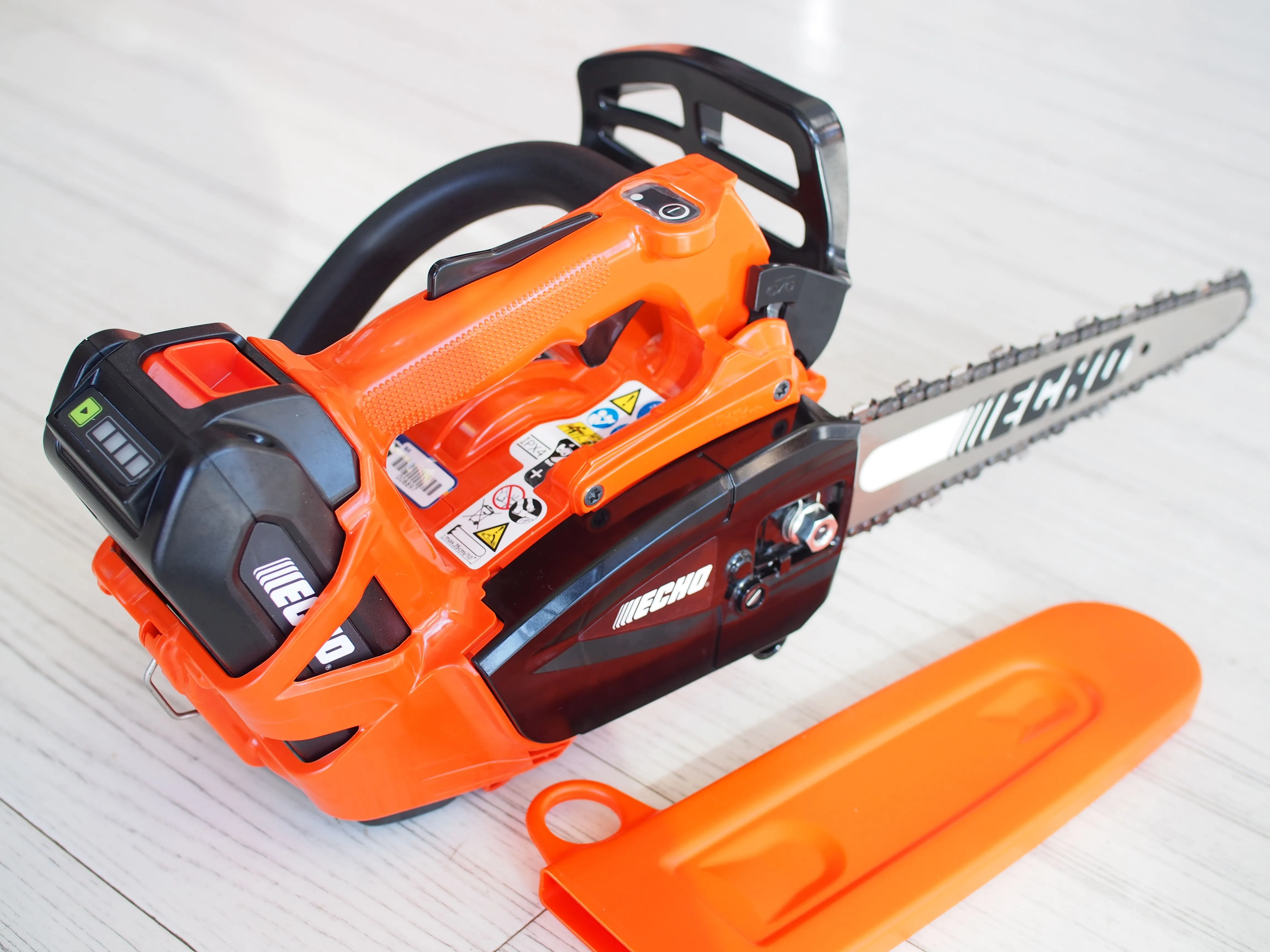 ECHOバッテリー式チェーンソー本体とオレンジ色のチェーンカバー